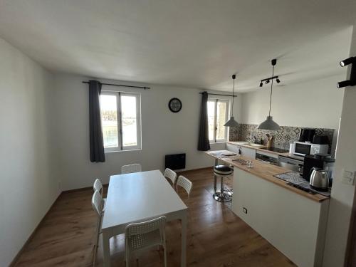 une cuisine avec une table et des chaises dans une pièce dans l'établissement La Vue du Rhône, à Arles