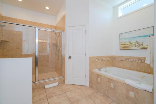 a bathroom with a bath tub and a shower at Stunning Beach Front-Private Heated Pool & Beach in Port Saint Joe