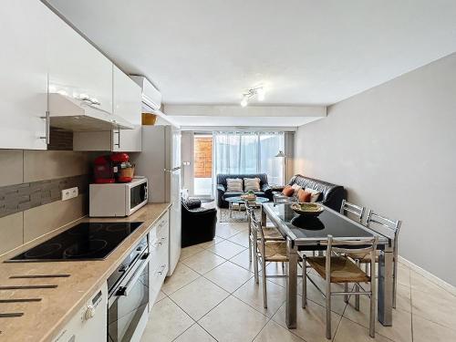 une cuisine et une salle à manger avec une table et des chaises dans l'établissement L'Illette, à Antibes