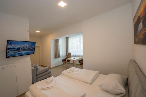 a room with a bed and a living room at Villa am Achenweg in Saalfelden am Steinernen Meer