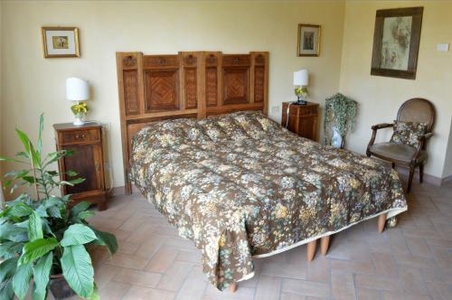 a bedroom with a large bed and two chairs at La Fornasaccia in Cesena
