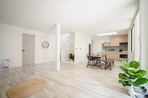 a white living room with a table and a dining room at Somewhere house in Bangkok