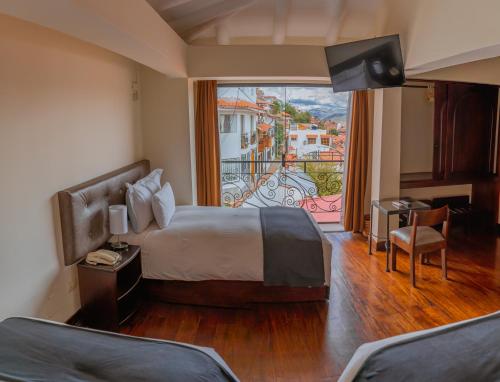 a hotel room with a bed and a large window at Hotel Encantada Casa Boutique Spa in Cusco