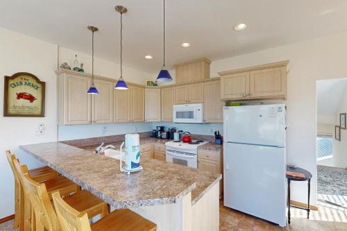 a kitchen with a white refrigerator and wooden cabinets at Ninos Al Mar in Rockaway Beach