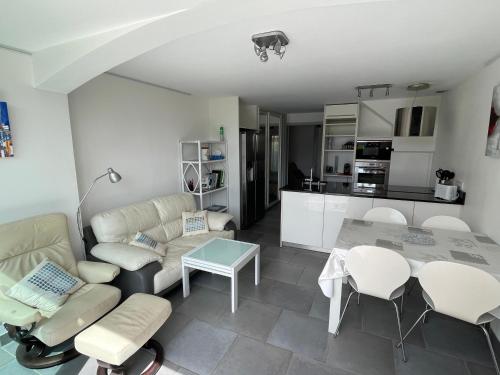 une cuisine et un salon avec une table et des chaises dans l'établissement DOUCEUR DU RIVAGE - 6pers - Histoire de Clés, au Cap d'Agde