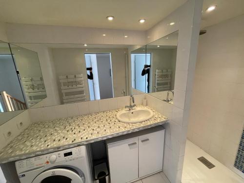 une salle de bain avec un lavabo et une machine à laver dans l'établissement DOUCEUR DU RIVAGE - 6pers - Histoire de Clés, au Cap d'Agde