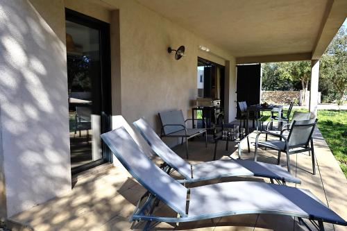 un groupe de chaises assises sur une terrasse dans l'établissement T3 neuf et moderne au cœur de Bonifacio, à Bonifacio
