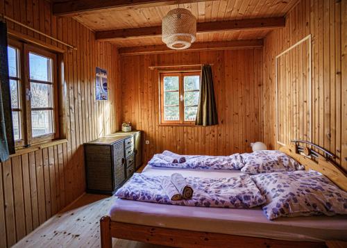 a bedroom with two beds in a wooden cabin at Zöldfenyő nyaraló, Ferienhaus Tannengrün in Balatonkeresztúr