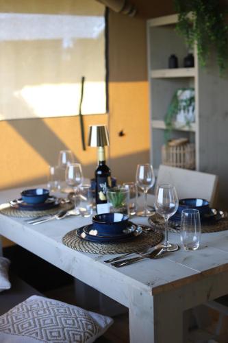 a table with plates and wine glasses on it at Safari Lodges Premium in Nieuwe Wetering