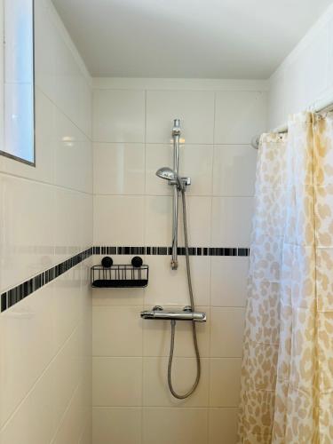 a shower in a bathroom with a shower curtain at Studio 41 Sunshine in Noordwijk aan Zee