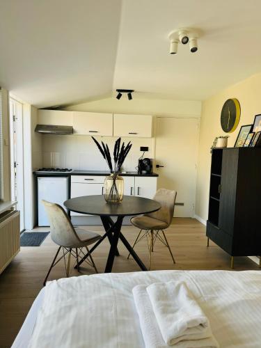 a room with a table and chairs and a kitchen at Studio 41 Sunshine in Noordwijk aan Zee