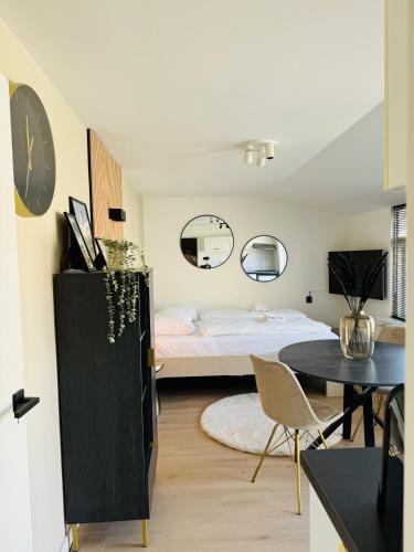 a bedroom with a bed and a table and chairs at Studio 41 Sunshine in Noordwijk aan Zee