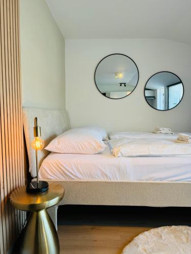 a bedroom with a bed with two mirrors on the wall at Studio 41 Sunshine in Noordwijk aan Zee