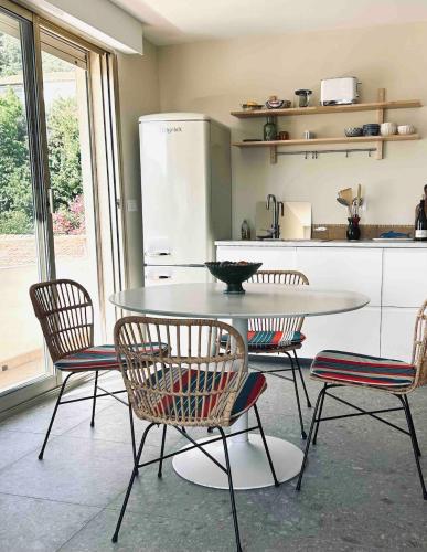 une cuisine avec une table, des chaises et un comptoir dans l'établissement LE NEPTUNE Jolie Déco, Balcon, Vue Mer, Centre Historique, à Sète