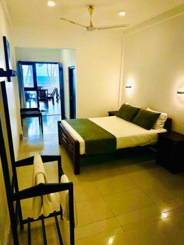 a bedroom with a bed and a chair in it at Sea Change in Talpe