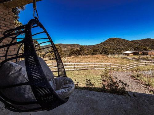a bag hanging from a porch with a view of mountains at Monte Sião Château in Urubici