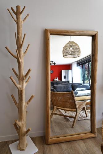 un miroir dans un salon avec un arbre dans l'établissement T4 Neuf et Moderne au cœur de Bonifacio, à Bonifacio