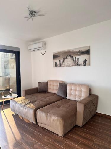Apartmani Beba في بار: غرفة معيشة بها أريكة بنية كبيرة
