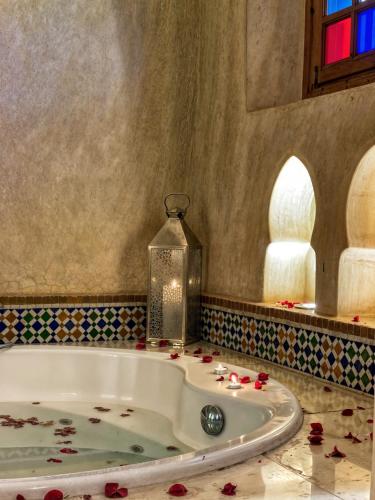 a bath tub in a bathroom with roses on the floor at Villa Taj Sofia & Spa in Marrakech