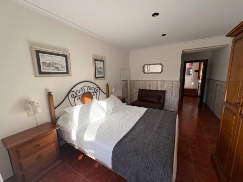 a bedroom with a large bed with white sheets at Posada Punta Liñera in San Vicente de la Barquera
