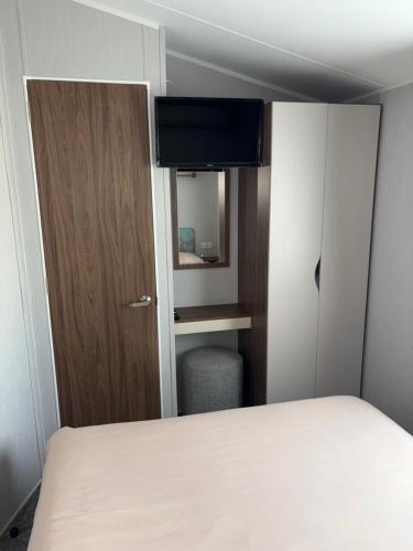 a small room with a bed and a mirror at McCanns Caravan Marton Mere in Blackpool