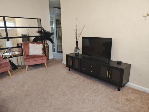 a living room with a flat screen tv on a entertainment center at ShayBnB in Portsmouth