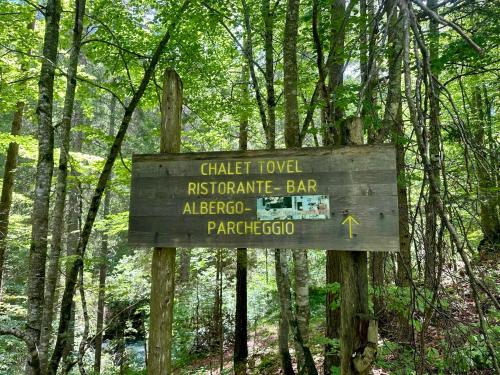 a wooden sign in the middle of a forest at Rifugio del Sole Apartment in Monclassico