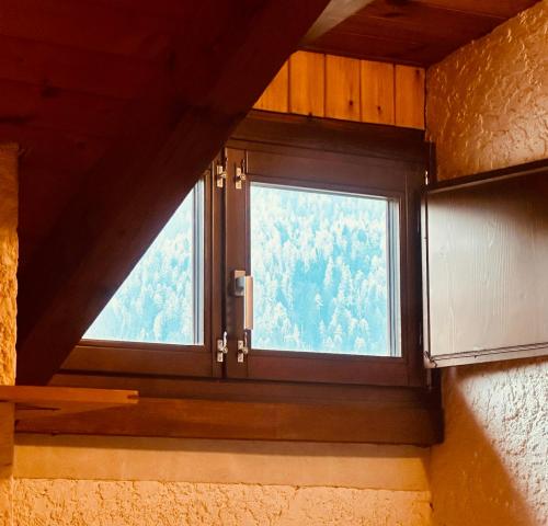 a window in a room with a view of trees at Rifugio del Sole Apartment in Monclassico