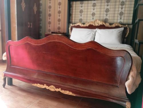 a bed with a wooden headboard in a bedroom at Jessica Flat Malta Royal Guesthouse in Cospicua