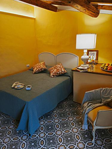 a bedroom with a bed and a yellow wall at La Funambola BB in Poggio Alla Croce