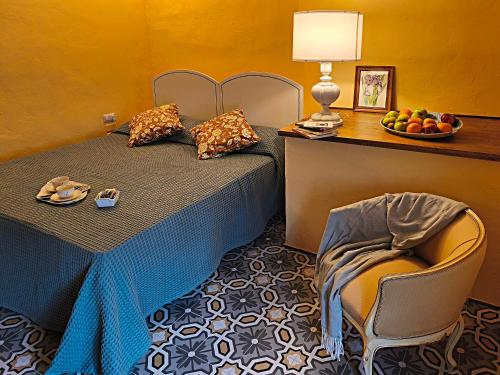a bedroom with a bed with a table and a chair at La Funambola BB in Poggio Alla Croce