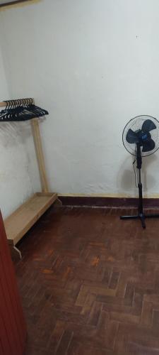 a room with a desk and a table next to a wall at Quarto econômico in São Luiz do Paraitinga