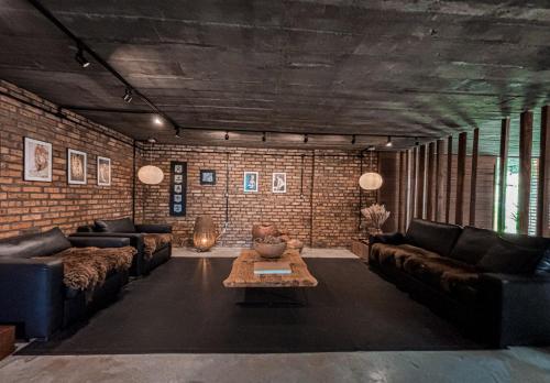a living room with couches and a brick wall at Monte Sião Château in Urubici