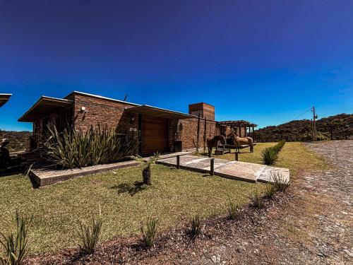 a brick house with a horse in front of it at Monte Sião Château in Urubici