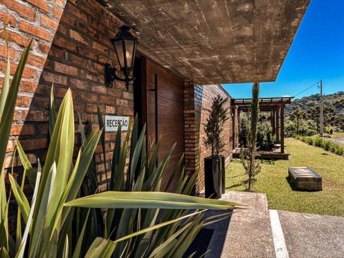 a brick house with a plant in front of it at Monte Sião Château in Urubici