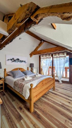 a bedroom with a large wooden bed in a room at Le Bataclan in Auron