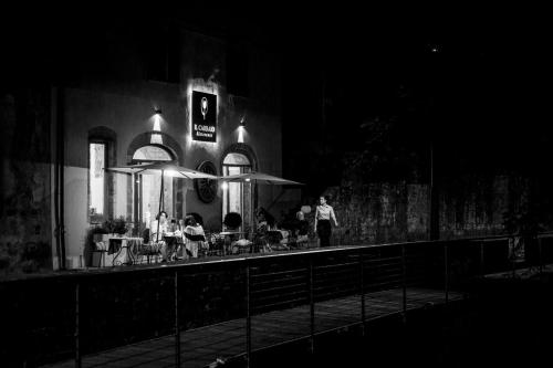 a group of people sitting outside a restaurant at night at Morelliana4Rooms in Scansano