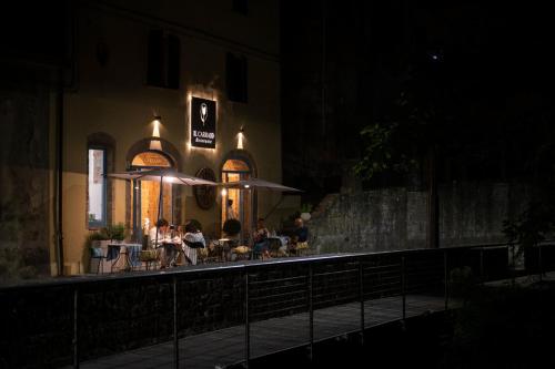 a group of people sitting at a restaurant at night at Morelliana4Rooms in Scansano