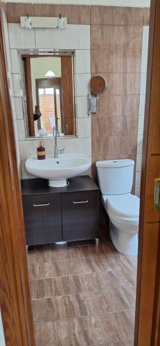 ein Badezimmer mit Waschbecken, Toilette und Spiegel in der Unterkunft Diolkos 2 in Nea Roda