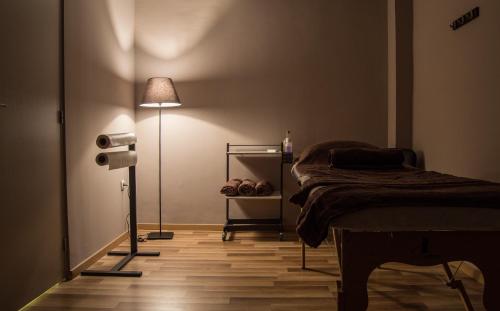 a bedroom with a bed and a floor lamp at Rebalance Apartments in Athens