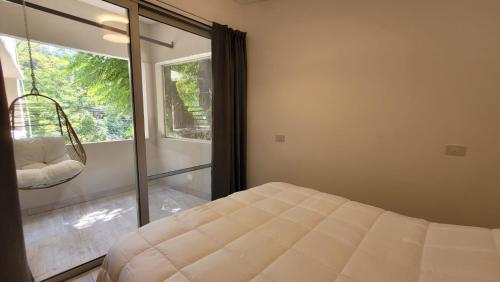 a bedroom with a bed and a large window at La Belle San Isidro Lofts in San Isidro