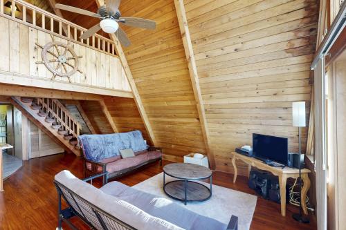 a living room with a ceiling fan and a staircase at Pirate's Paradise in Lincoln City