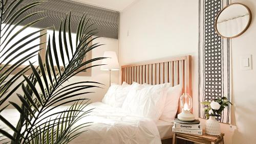 a bedroom with a bed with white pillows and a plant at Lucky Vicky House in Seoul