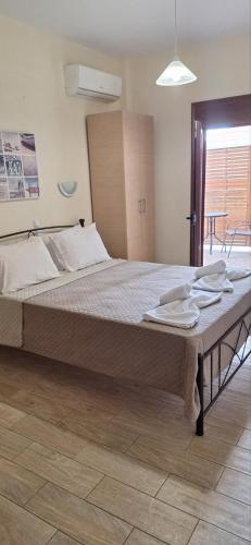 ein Schlafzimmer mit einem großen Bett, auf dem Handtücher liegen in der Unterkunft Diolkos 2 in Nea Roda
