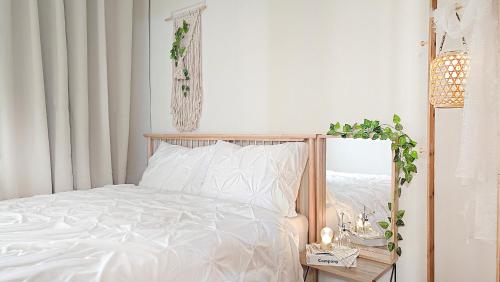 a white bedroom with a white bed and a table at Lucky Vicky House in Seoul