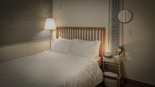 a bedroom with a white bed with a lamp and a mirror at Lucky Vicky House in Seoul