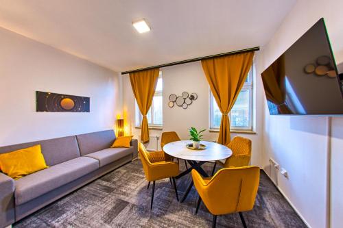 a living room with a couch and a table and chairs at Národní dům Podbořany in Podbořany