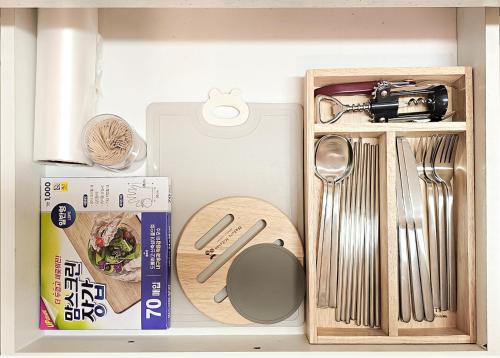a drawer filled with kitchen utensils and a box at Lucky Vicky House in Seoul