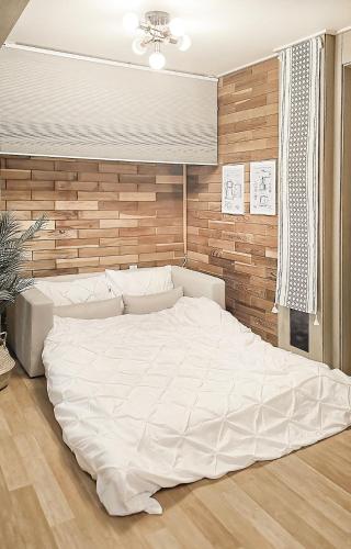a large white bed in a bedroom with a wooden wall at Lucky Vicky House in Seoul