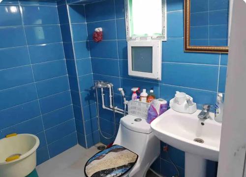 a blue bathroom with a toilet and a sink at F2 Maison avec jardin à Constantine in Hamma Bouziane